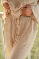 Bottom close up of model wearing cream Long Button Up Pyjamas