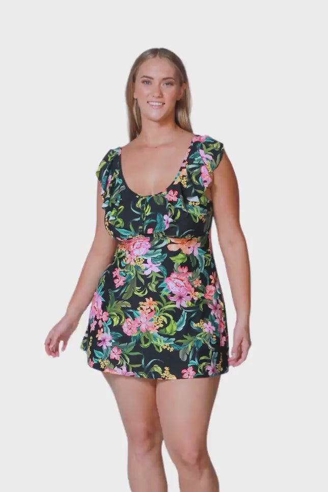 blonde plus size swimwear model wears green floral swim dress with frill detail