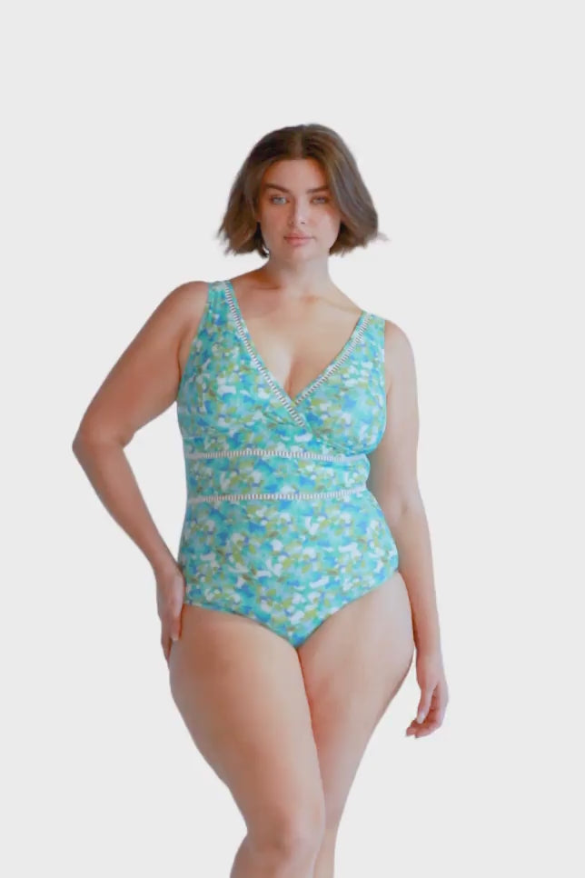 brunette model wears aqua blue v neck one piece swimsuit