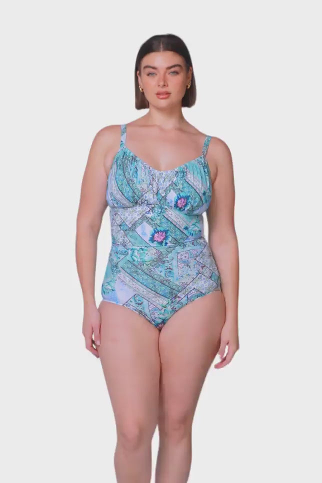 brunette size 14 women wearing sky blue underwire one piece with ruching in a patchwork print