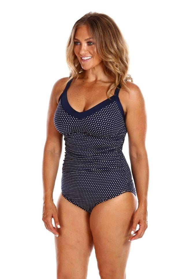 blonde model wearing navy and white dots supportive underwire one piece swimsuit