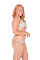 redhead women wearing swim bottoms in retro floral that tie up at the sides 