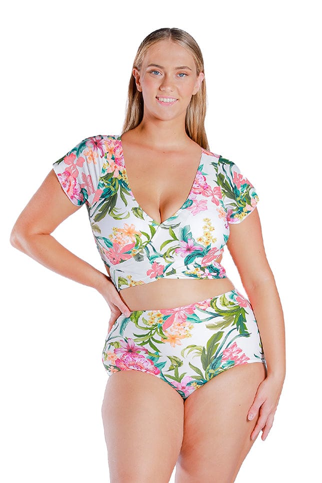 plus size women wearing white and pink floral cap sleeve bikini top with matching high waisted pant