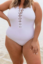 blonde model wearing white lace up one piece swimsuit